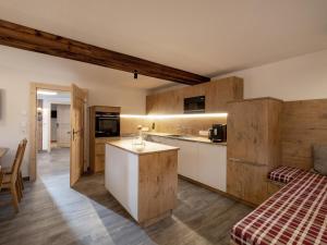 eine Küche mit Holzschränken und einer Arbeitsplatte in der Unterkunft Appartement Am Hof Untertann in Kirchberg in Tirol