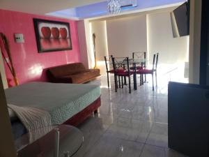 Hotel Torres Gemelas vista al mar a pie de playa في أكابولكو: غرفة معيشة مع طاولة وغرفة طعام