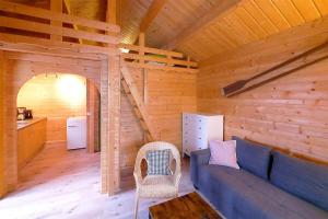 ein Wohnzimmer mit einem blauen Sofa in einer Hütte in der Unterkunft Urlaub im Fischland Scharmützelsee in Wendisch Rietz