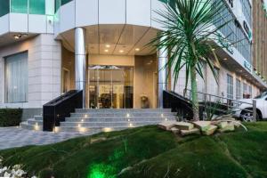 a building with stairs and a palm tree in front of it at Duset Suites in Riyadh