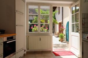 eine Küche mit einer offenen Tür mit Blumen in der Unterkunft Ferienwohnung im Sternenhof in Großkarlbach