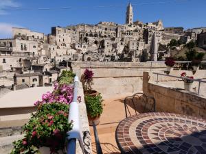 a view of a city from a balcony with a table and flowers at Casa Vacanza La Cava nel Barisano Suite Matera in Matera