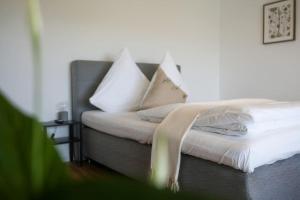 a bed with white pillows on top of it at Boho Stil Wohnung mit Flussblick nahe Stadtzentrum in Koblenz