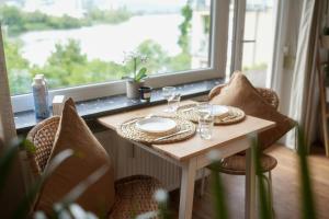 a table with glasses and plates on it in front of a window at Luxuriöse Wohnung mit Flussblick nahe Stadtzentrum in Koblenz