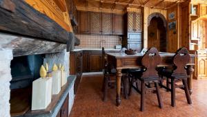 a kitchen with a table and chairs and a fireplace at Italianway - Teregua 2 in Valfurva