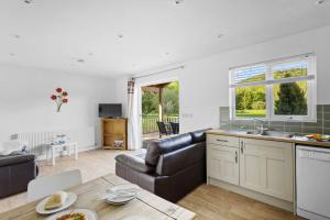 a kitchen and living room with a couch and a table at Kingfisher Lodge, Redlake Farm, Nr Glastonbury in Somerton