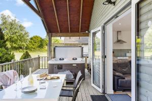 a patio with a grill and a table on a deck at Kingfisher Lodge, Redlake Farm, Nr Glastonbury in Somerton