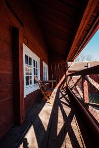 a porch of a wooden cabin with a chair and a window at Vandrarhemmet Färgaren in Eksjö