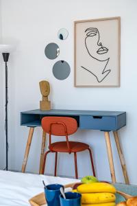 a desk with a chair and a picture on the wall at Heart Location & PARKING in Málaga