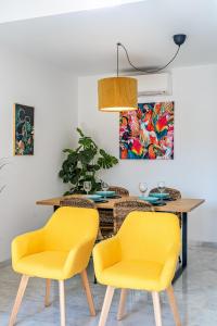 a dining room with yellow chairs and a table at Heart Location & PARKING in Málaga