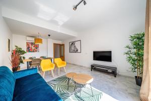 a living room with a blue couch and a table at Heart Location & PARKING in Málaga