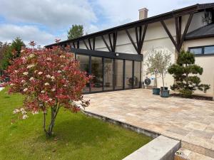 una casa con un árbol en el patio delantero en MILIA wine & event resort, en Dunajský Klátov