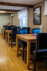 eine Reihe von Holztischen und -stühlen in einem Restaurant in der Unterkunft Vandrarhemmet Färgaren in Eksjö