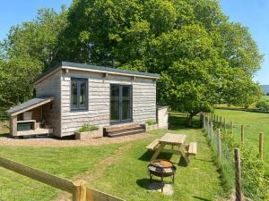 a small shed with a picnic table in a yard at Impeccable shepherds hut sleeping up to 4 guests in Minehead