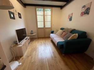 ein Wohnzimmer mit einem Sofa und einem TV in der Unterkunft Studio mezzanine avec Terrasse privative cosy - REF MIMONT in Cannes