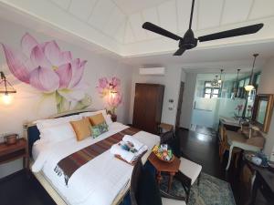 a bedroom with a large bed with pink flowers on the wall at The Knight House Bangkok in Bangkok