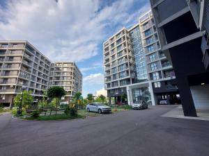 ソフィアにあるINTER EXPO APARTMENTの駐車場に車を停めた高層ビル2棟 +5枚の写真