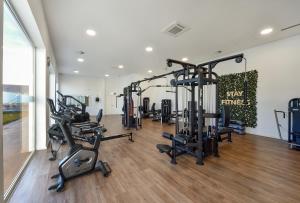 einen Fitnessraum mit mehreren Laufbändern und Heimtrainern in der Unterkunft Serpa Hotel in Serpa