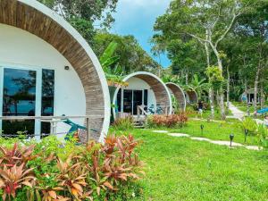 Tube Resort في كوه رونغ ساملوم: صف اكواخ مع اقوس في حديقة