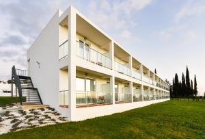 an exterior view of a white building with a lawn at Serpa Hotel in Serpa