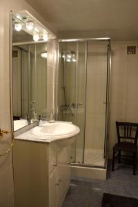 ein Bad mit einem Waschbecken und einer Dusche in der Unterkunft Le Jardin Secret in Saint-Antonin