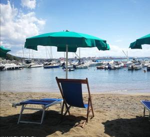 a couple of chairs and an umbrella on a beach at Castiglioncello Suite in Castiglioncello