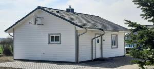 un pequeño edificio blanco con techo inclinado en Ferienhaus Casa Baltica, en Gelting