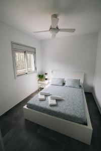 biała sypialnia z łóżkiem z 2 ręcznikami w obiekcie Vista al Mar, a 1a linea de la Bahía dels Alfacs. w mieście Alcanar