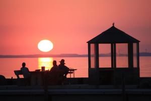 um grupo de pessoas sentadas numa mesa a ver o pôr-do-sol em Ferienhaus Casa Baltica em Gelting