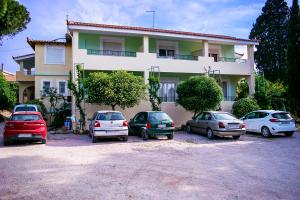 um grupo de carros estacionados em frente a um edifício em Kleidas Apartments em Thymianá