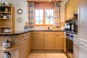 a kitchen with wooden cabinets and a window at Apartment Hori - GRIWA RENT AG in Grindelwald