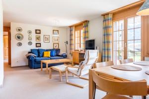 een woonkamer met een blauwe bank en een tafel bij Apartment Hori - GRIWA RENT AG in Grindelwald