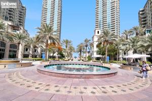 fontanna w środku miasta z wysokimi budynkami w obiekcie bnbme - Dubai Marina 2BR Apt w Private Jacuzzi Pool Gym Near JBR Beach & Marina Walk w Dubaju