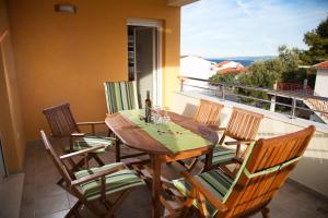 a wooden table and chairs on a balcony at Apartments Medvid in Trogir