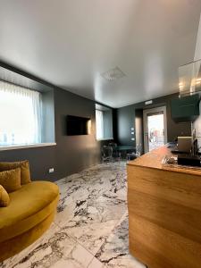 a living room with a yellow couch and a kitchen at Vulcano Palace in Castro