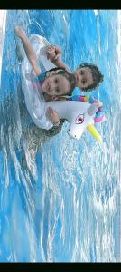 three children in a pool with a toy shark in the water at Anmol Hotel Thai Smile Group in Pattaya Central