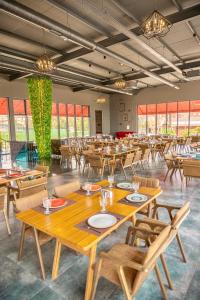 Un restaurante con mesas y sillas de madera y ventanas. en Panorama Villa Lux Hotel, en Baku