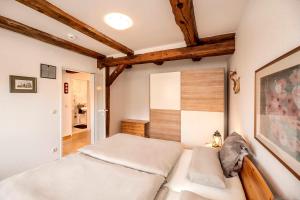 バート・ベヴェンセンにあるFerienwohnung Johnsの白いベッドと木製の天井が備わるベッドルーム1室が備わります。