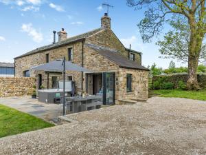 an external view of a stone house with an umbrella at Holme House in Eldroth