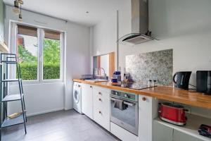 a kitchen with white cabinets and a counter top at L'escapade in Schiltigheim