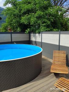 a hot tub and two chairs on a wooden deck at Berg & See Appartements in Hermagor