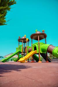 Un patio de juegos con un tobogán verde en un parque en Panorama Villa Lux Hotel, en Baku