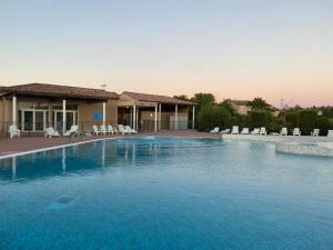 a large swimming pool with chairs and a house at Résidence Les Demeures du Ventoux in Aubignan