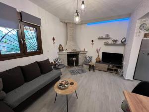 uma sala de estar com um sofá e uma lareira em Natural House with Pool & private parking em Heraclião
