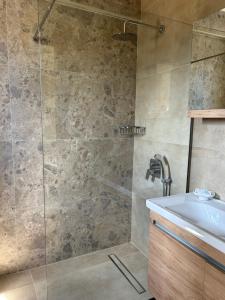 a bathroom with a shower and a sink at Georges Estates Hotel in Stoupa