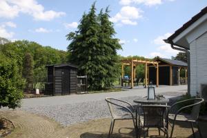 un patio con mesa, sillas y un árbol en B&B Hoeve de Veldmaat, en Haaksbergen