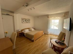 1 dormitorio con 1 cama, mesa y sillas en Apartment Parčina, en Trogir