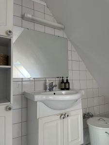 a white bathroom with a sink and a toilet at Løkken Family Camping & Guesthouse in Løkken