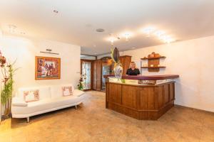 a woman standing at a bar in a salon at Hotel Wenger Alpenhof in Werfenweng