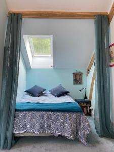 a bedroom with a bed with blue walls and a window at Jardin face aux Pyrénées in Gelos